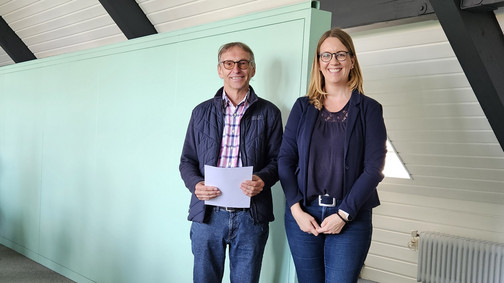 OV Vorsitzende und Jubilar stehen nebeneinander mit einem Geschenk