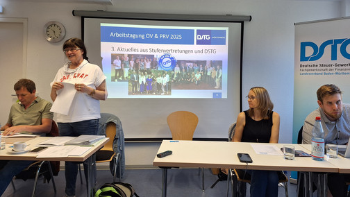 Die Vorsitzende steht vor den Teilnehmern