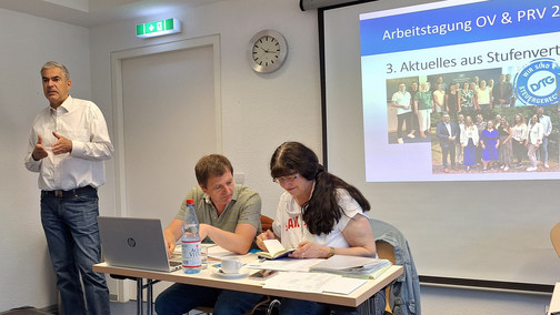 Der Vorsitzende steht vorne im Saal