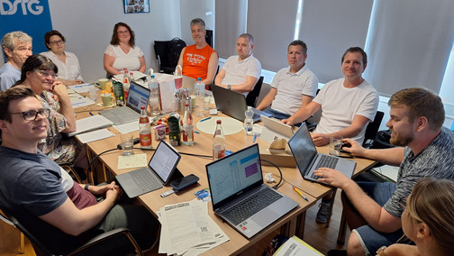 Mehrere Personen sitzen um einen großen Tisch